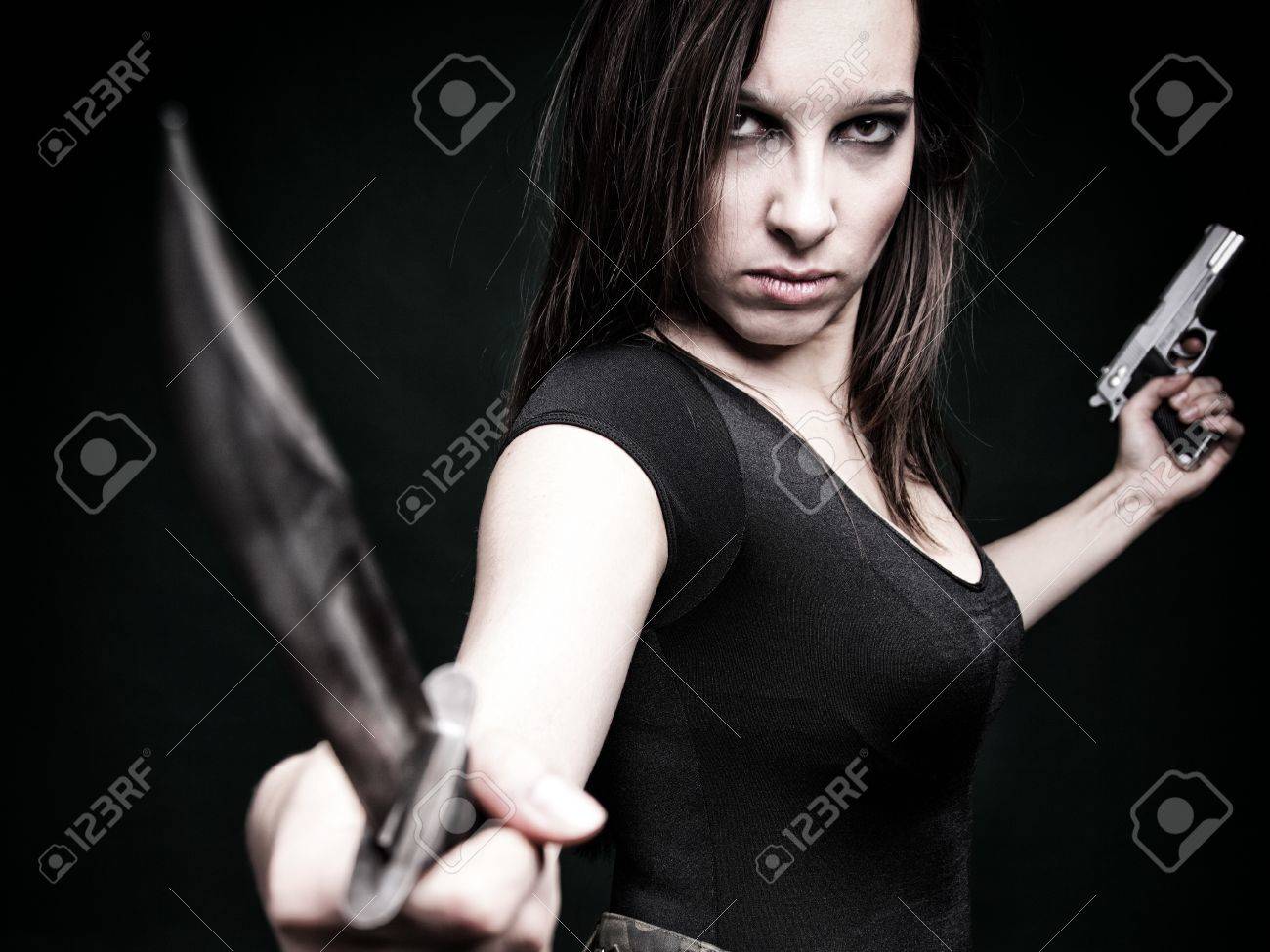 13382509-Sexy-young-woman-in-red-with-a-gun-knife-on-green-background-Stock-Photo.jpg